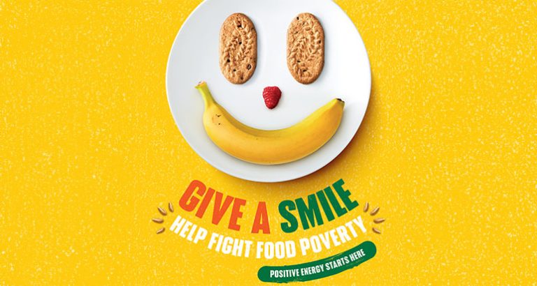 Smiling face made from a banana, a raspberry and two biscuits for eyes